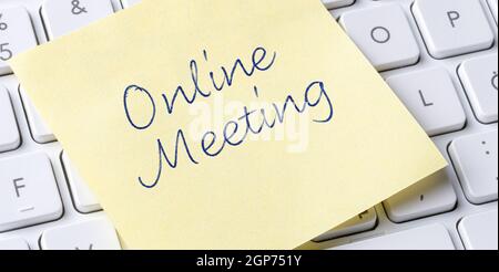 Sticky note on a keyboard - Online Meeting Stock Photo