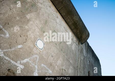 Lower view of one of the last remaining remains of the Berlin Wall (1961-1989) at the Wall Memorial in Berlin-Mitte in November 2011 in front of a blu Stock Photo