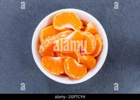 Mandarin oranges fruits from above bowl on a slate Stock Photo