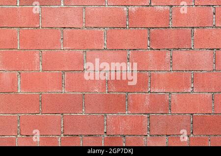 Modern red brick wall background with cracks in concrete Stock Photo