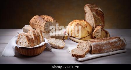 Different types of traditional bread on wooden table, space for text. Stock Photo