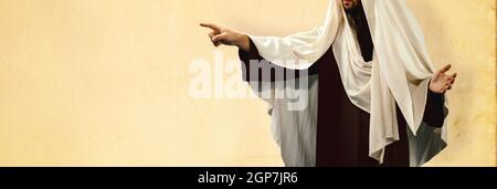 Man wearing Jesus Christ costume pointing with hand and finger to the side. Stock Photo