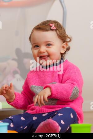 Toddler baby girl plays with soft rubber building blocks. Stock Photo