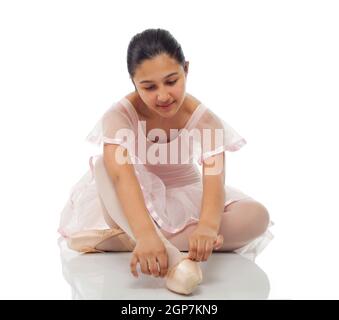 Young dancer while tying his shoes for dancing on white background. Stock Photo