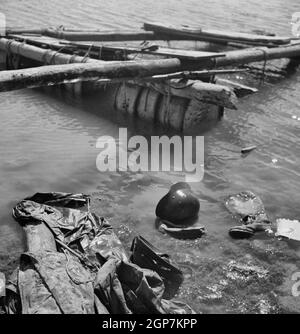 Porto Farina, Tunisia. A German raft, boot and helmet in water after American and British soldiers frustrated the evacuation attempt of German 10th and 15th panzer divisions - May 1943 Stock Photo