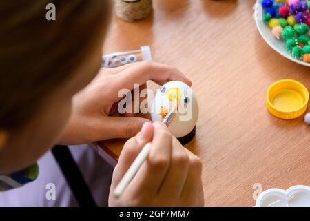 Close-up of hands of a child painting Easter eggs Stock Photo