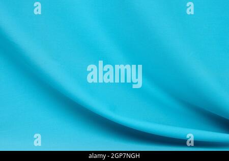 Textured background made of soft blue fabric with elegant pleats. Selective focus. Stock Photo