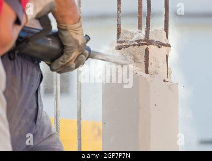Workers break reinforced concrete with jackhammer at a construction site Stock Photo