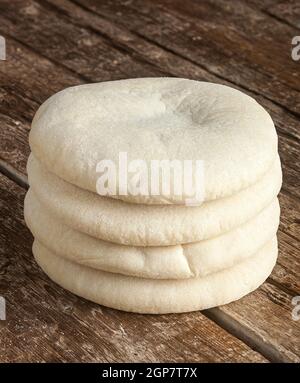 Four loaves of Arabic bread on the wooden table. Stock Photo