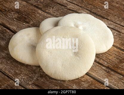 Four loaves of Arabic bread on the wooden table. Stock Photo