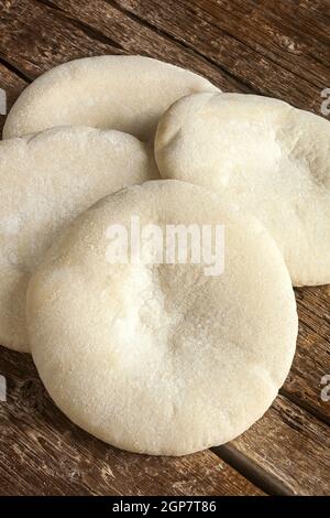 Four loaves of Arabic bread on the wooden table. Stock Photo