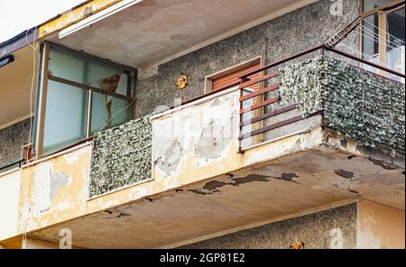 Balcony with cracked concrete and rusty irons requiring renovation. Stock Photo