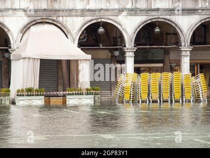 Tables and chairs with high water in Saint Mark's square, Venice, Italy. Stock Photo