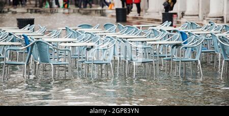 Tables and chairs with high water in Saint Mark's square, Venice, Italy. Stock Photo