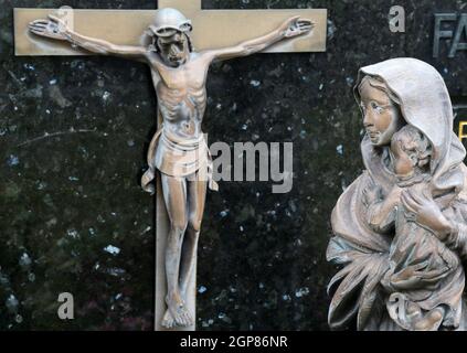 Virgin Mary with baby Jesus looks at Jesus crucified on the cross, Cemetery in Hohenberg, Germany Stock Photo