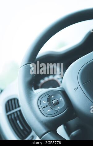 Close up of a steering wheel with remote control, blurry dashboard Stock Photo