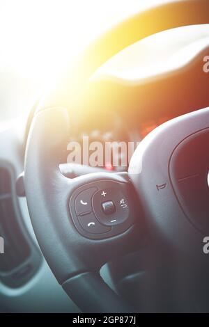 Close up of a steering wheel with remote control, blurry dashboard Stock Photo
