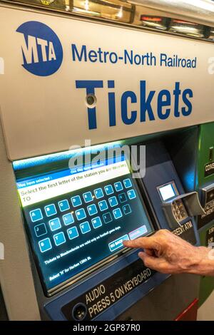 Man Purchasing Metro North Transit Train Tickets at Self Serve Vending Machine, Grand Central Terminal, NYC Stock Photo