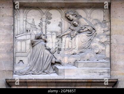 Virgin giving the Rosary to Saint Dominic, by Theodore Charles Gruyere, relief on the portal of Saint Thomas Aquinas in Paris, France Stock Photo