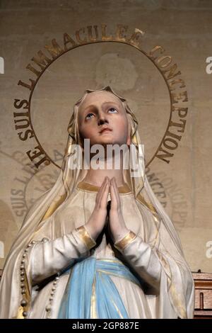 I Am the Immaculate Conception, Our Lady of Lourdes, statue in the St Francis Xavier's Church in Paris, France Stock Photo