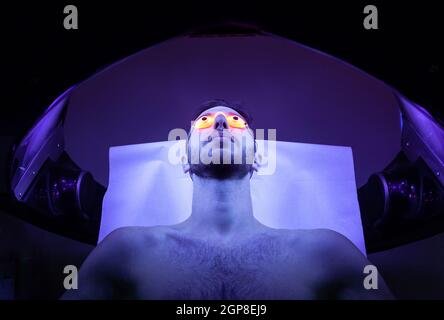 Young Thin Man At Solarium In Beauty Salon. Stock Photo
