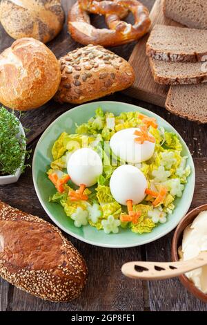 Easter breakfast with hard boiled eggs and bread rolls Stock Photo