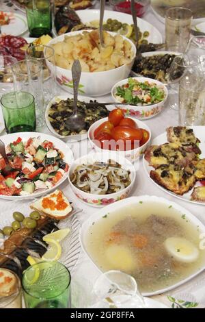 Holiday table setting. Festive table with delicious dishes. Many food on table for family holiday. Festive food served on table. Set of different meat Stock Photo