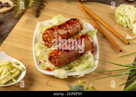 Fried pork spring rolls served with sweet chili topping Stock Photo