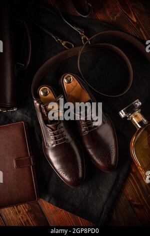 Men leather shoes, belt and diary on wooden background, top view, flat lay Stock Photo