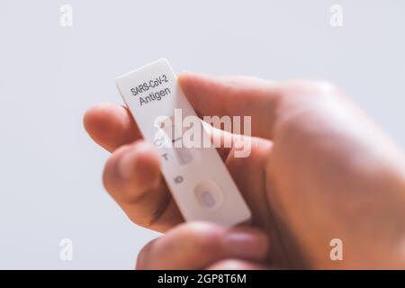 Close up of fingers holding express antigen covid test, negative result Stock Photo