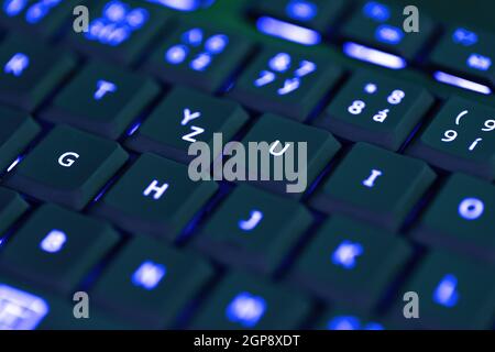 Closeup of laptop or desktop computer keyboard illumination, blue backlit keyboard Stock Photo
