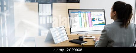 Woman Using Finance Spreadsheet Report On Laptop Screen Stock Photo