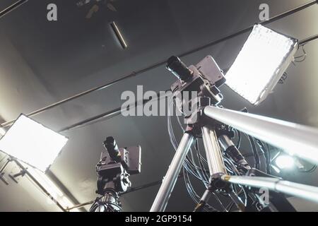 Film camera on a tripod in a television broadcasting studio, spotlights and equipment Stock Photo