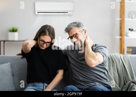 Air Conditioner Couple Sneezing And Having Sore Neck Stock Photo