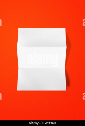 Blank folded White A4 paper sheet mockup template isolated on red background Stock Photo