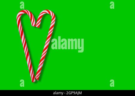 Christmas candy canes and lollipops isolated on green. Banner for winter holidays design. Stock Photo