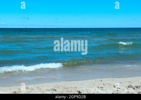 Sea waves on sand. Ocean waves beat against waves on beach. Sea water. Soft beautiful ocean wave on sandy beach. Splashing ocean waves. Marine beach. Stock Photo