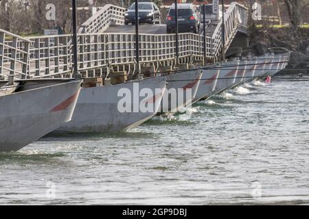 row of prows at pontoon bridge on Ticino river clear waters, shot on bright winter day at Bereguardo, Pavia, Lombardy, Italy Stock Photo