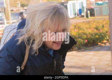 Attractive tourist stands in front of a map during a hiking tour Stock Photo