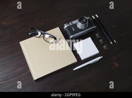 Blank stationery and vintage camera on wood table background. Stock Photo