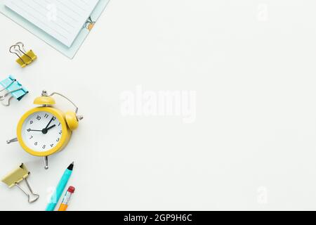 Paper clips, mechanical clock, pen, pencil and notepad on white background. Work and education concept. High quality photo Stock Photo