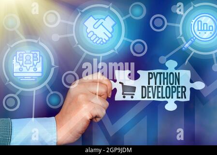 Text sign showing Python Developer. Business concept responsible for writing serverside web application logic Hand Holding Jigsaw Puzzle Piece Stock Photo
