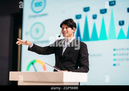 Asian Businessman Stands on Stage for Business Presentation Stock Photo