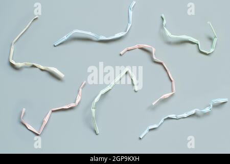 Used plastic drinking straws on the grey background top view. Single-use plastic problem Stock Photo