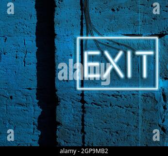 inscription exit from glowing neon blue lamps hangs on a brick wall, night Stock Photo