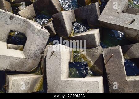 Breakwater blocks in the port. Breakwater of the rectangular stone figures. Stock Photo