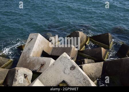 Breakwater blocks in the port. Breakwater of the rectangular stone figures. Stock Photo