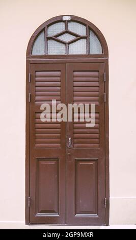 Vintage arched shutters, two panel rustic Mediterranean Shutter. Old wooden vintage louver window. Blinds Window Shutter Plantation Shutter in brown. Stock Photo