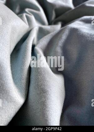 Ruffled bed sheets with sun shining on them Stock Photo
