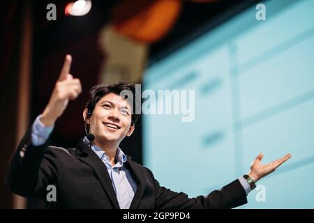 Asian Businessman Stands on Stage for Business Presentation Stock Photo